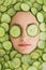 Beautiful woman with facial mask of cucumber slices on face