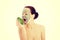 Beautiful woman with facial mask holding avocado.