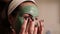 Beautiful woman with facial mask. Spa therapy for young woman receiving facial mask.