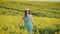 beautiful woman farmer enjoys rape crop, beauty spring yellow blooming field