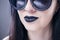 Beautiful woman fashion model portrait in sunglasses with black lips and earrings. Creative hairstyle and make up