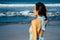 Beautiful woman with flying long butterfly blue chiffon dress posing on beach