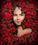 Beautiful woman in a frame of flowers. Young girl with red peony roses