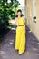 Beautiful woman in full length posing in long yellow party dress