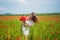 Beautiful woman gather red poppy flower bouquet in field. summer or spring nature. seasonal beauty landscape. young girl