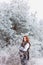 Beautiful woman with a gentle sweet bright red hair walking on a frozen snowy woods