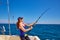 Beautiful woman girl fishing rod trolling in boat