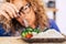 Beautiful woman with glasses looking with disgust some vegetables and rise on the table - she is going to eat healthy to feel