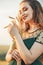 Beautiful woman in green dress on field with sheaf of wheat in hand at sunset light, girl enjoying summer nature landscape,