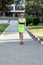 The beautiful woman in a green dress goes on the sidewalk