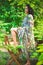 Beautiful woman in a green garden posing on a vintage chair