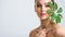 Beautiful woman with green leave near face and body.  Closeup girl`s face with green leave. Skin care beauty treatments concept