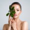 Beautiful woman with green leave near face and body.  Closeup girl`s face with green leave. Skin care beauty treatments concept