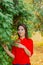 Beautiful woman in a green tree arborvitae.