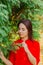 Beautiful woman in a green tree arborvitae.