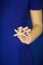 Beautiful woman hands with perfect nail polish holding little starfish in front of blue dress