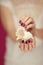 Beautiful woman hands with perfect pink nail polish holding little sea shell