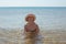 Beautiful woman in hat and bikini in sea water smiling. Summer pastime and relaxation