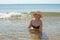 Beautiful woman in hat and bikini in sea water smiling. Summer pastime and relaxation