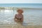 Beautiful woman in hat and bikini in sea water smiling. Summer pastime and relaxation