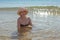 Beautiful woman in hat and bikini in sea water smiling. Summer pastime and relaxation