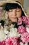 Beautiful woman in hat posing with many peony flowers. Happy mother with big bouquet of pink peonies from children. Happy Mothers