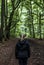 Beautiful woman hiker standing on forest trail looking away. Female on hike in nature spooky mystical forests