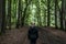 Beautiful woman hiker standing on forest trail looking away. Female on hike in nature spooky mystical forests