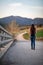 Beautiful woman hiking over a bridge with the path and mountains blurred on the background