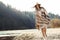 beautiful woman hipster walking on river beach in mountains, having fun and enjoying, boho travel concept, space for text