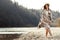 beautiful woman hipster walking on river beach in mountains, having fun and enjoying, boho travel concept, space for text