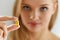 Beautiful Woman Holding Fish Oil Pill In Hand. Healthy Nutrition