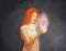 A beautiful woman holding a glowing heart in her hands. Self-love symbol, finding love