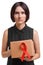 Beautiful woman holding the red ribbon, symbol of AIDS awareness isolated on a white background. World AIDS day concept.