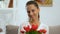 Beautiful woman holding red tulips bouquet and smiling, holiday celebration