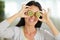 Beautiful woman holding two cut kiwis on eyes