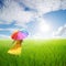 Beautiful woman holding umbrella in green grass field and bule sky