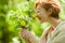 Beautiful woman holding wild herbs, smelling and smiling