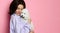 Beautiful woman hugging her lovely poodle dog puppy on pink