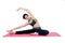 Beautiful woman indoor exercising using pink yoga mat