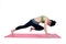 Beautiful woman indoor exercising using pink yoga mat