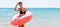 Beautiful woman inside donut rubber ring is enjoying the sea and looks happy