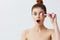 beautiful woman jade face massager wrinkle smoothing tied hair in a bun  background