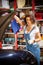 Beautiful woman in a jeans jumpsuit of a car mechanic opened the