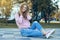 Beautiful woman in jeans and a sweatshirt in the street sneakers autumn park