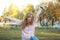 Beautiful woman in jeans and a sweatshirt in the street sneakers autumn park smiling happy