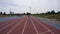 A beautiful woman jogger starts running at the city athletics stadium during a day training in slow motion 4K video on