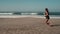 Beautiful woman is jogging along sandy ocean shore