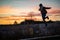 Beautiful woman jumping from a concrete block during sunset