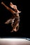 Beautiful woman jumps on trampoline at dark time and performs trick upside down